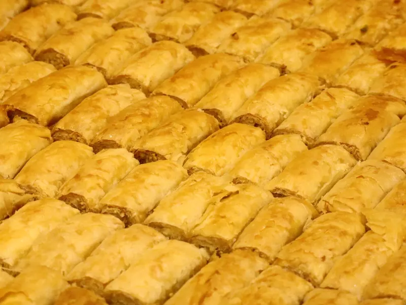 שורות צפופות של אצבעות בקלאווה זהובות ופריכות במגש גדול.