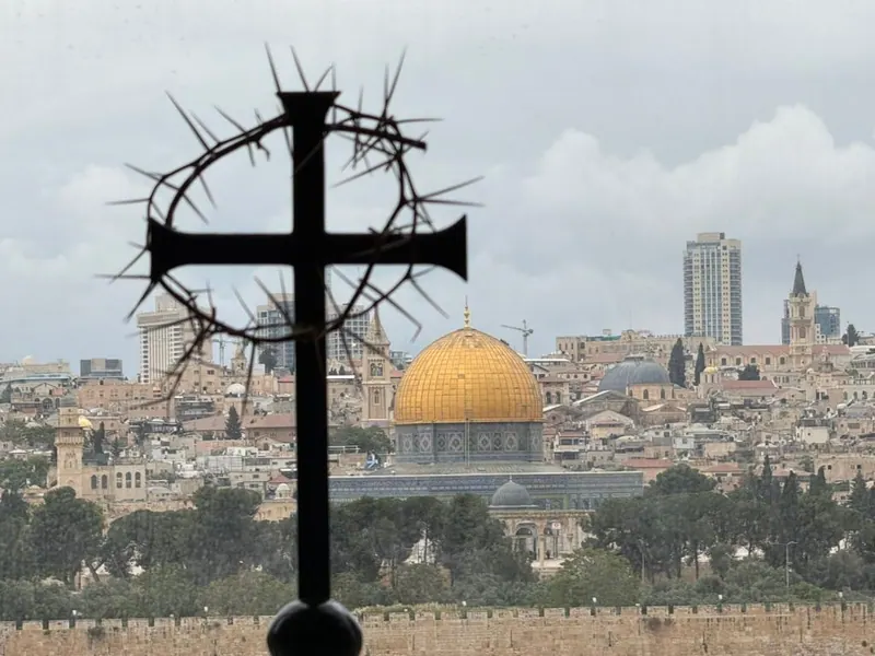 צללית של צלב שחור עטור זר קוצים, ומאחוריו כיפת הסלע המוזהבת ובתי העיר.
