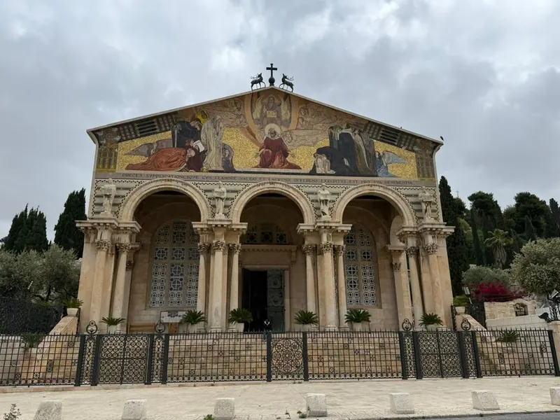 חזית כנסיית כל העמים בגת שמנים: שלוש קשתות על עמודים ומעליהן גמלון מעוטר בפסיפס צבעוני על רקע זהב.