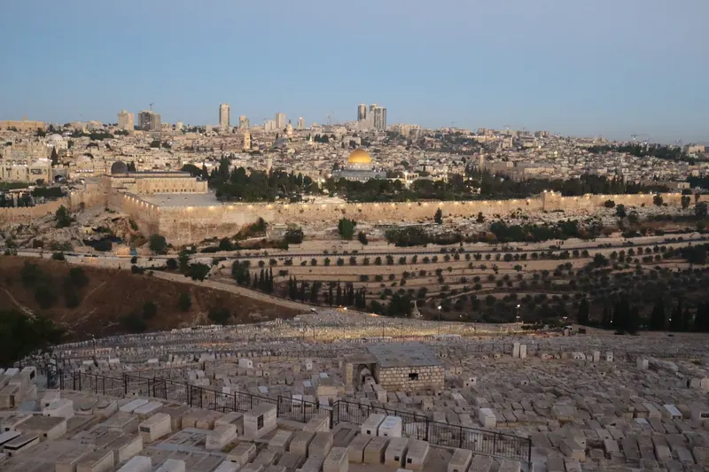מבט מהר הזיתים מעל קברי בית הקברות היהודי אל חומת העיר העתיקה וכיפת הסלע, עם רדת הערב.
