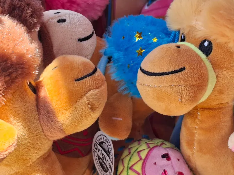 גמלי פרווה חומים לצעצוע בדוכן מזכרות, צפופים זה לצד זה.