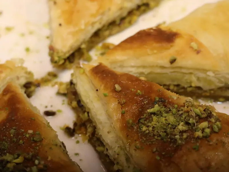 משולשי בקלאווה מבצק עלים עם מילוי וזרייה של פיסטוק.
