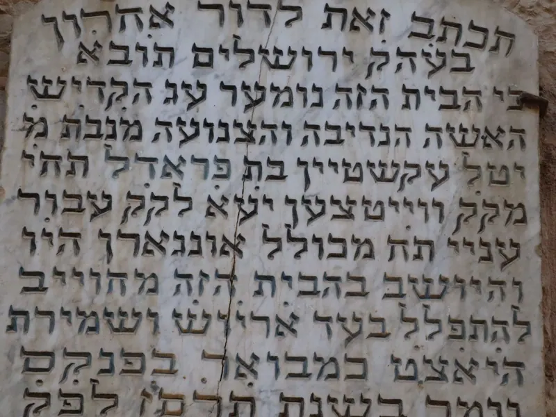לוח שיש סדוק ועליו כתובת הקדשה עברית חקוקה: "תכתב זאת לדור אחרון בעה"ק ירושלים ת"ו".